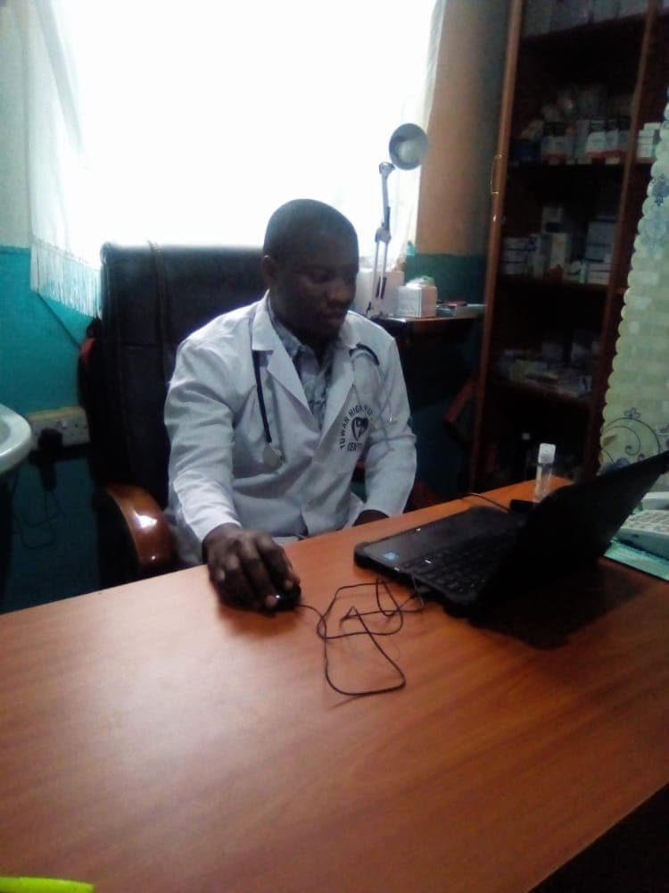 A clinician at AMI Ruhama Church Waraba Mission Hospital reviewing patient care